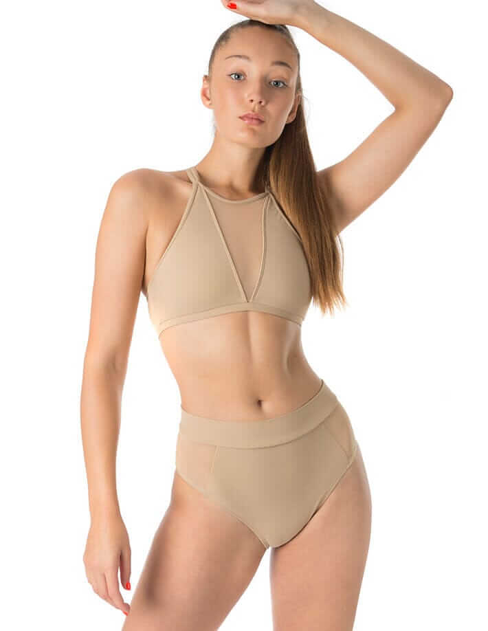 Femme en sous-vêtements beige, montrant un modèle sculptant et confortable pour le sport ou la danse.