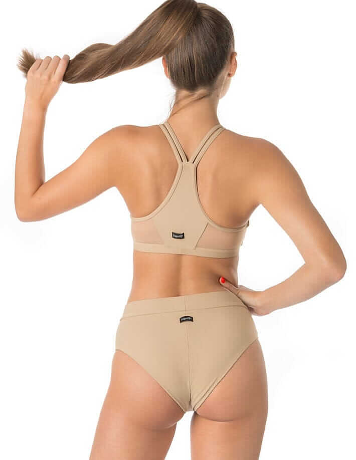 Woman wearing beige mesh pole dance shorts and matching top from the back, showing stylish design and fit.